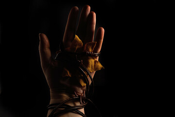 Holocaust Remembrance Day. Hand and barbed wire on black background.