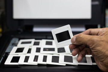 Close-up view of the hand picked up a lot of slide films arranged in rows.