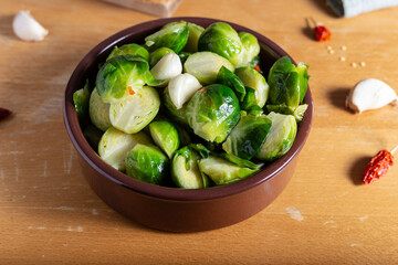 Brusselle spout with garlic on a wooden background.