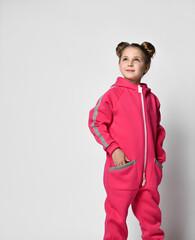 waist-length portrait of a stylish girl in a pink sports suit with reflective stripes, looks to the side. stylish cotton tracksuit, pajamas with a hood, a fashion model for children.