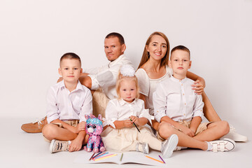 family of five is hugging on a white background. children draw with pencils on a white background