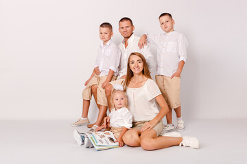 happy parents and three beautiful children embrace on a white background