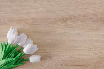 Fototapeta na wymiar Creative layout made with bouquet of white tulips on wooden background. Flat lay. Spring minimal concept.