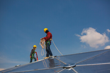 Male workers rope access height safety connecting with a knot safety harness, to ascending, construction site oil tank dome.