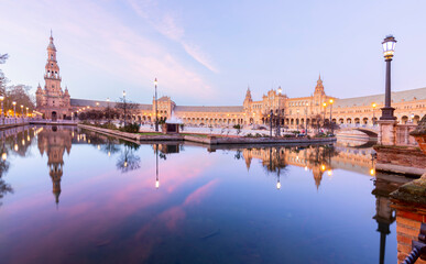 scenic view of Plaza de EspaÃ±a The Plaza de EspaÃ±a is a plaza in the Parque de MarÃ­a Luisa, Historical landmark in Seville sunset, Spain