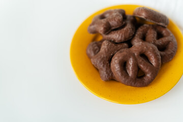 Gingerbread in chocolate lies on a yellow plate. Place for an inscription.