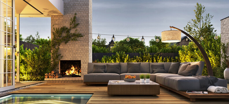 Outdoor patio area with garden furniture, swimming pool and outdoor fireplace. Evening view