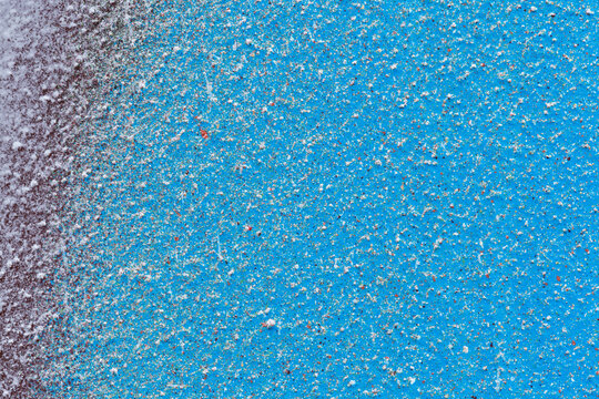 Macro close-up of light blue and dark red spray paint with white and colorful splashes. Abstract full frame textured splattered graffiti background with copy space.