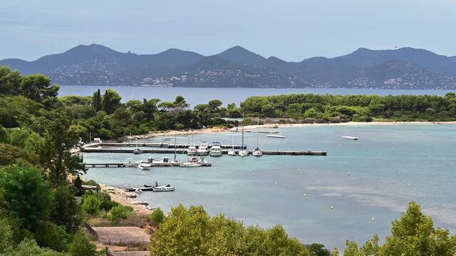 View of the Mediterranean sea coast on the Island of Sainte-Marguerite, a lot of greenery, piers with moored boats, France