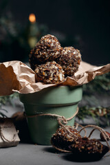 Chocolate truffle with hazelnut topping. Against the background of Christmas trees.
