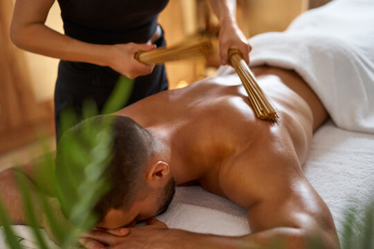 Man having bamboo sticks massage