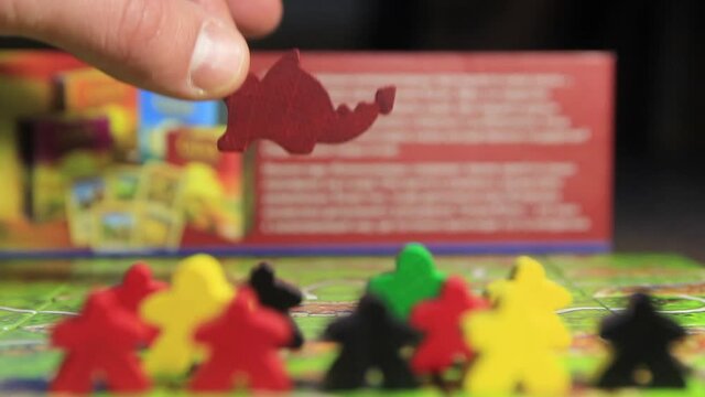Board game carcasson with tiles and wooden playing pieces close-up.
