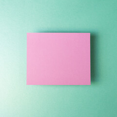 Obraz na płótnie Canvas Pink blank memo pad isolated on mint green background. top view, copy space