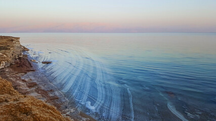 View of Dead Sea coastline. Salt crystals at sunset. Texture of Dead sea. Salty sea shore. Landscape Dead Sea coastline in summer day,  failures of the soil
