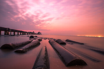 The background of the sea by the evening sea, with natural beauty (sea water, rocks, sky) and fishermen are fishing by the river bank, is a pleasure during travel.