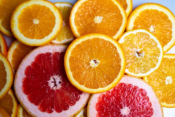 Fototapeta na wymiar Slises of different citruses on the white background. Close-up of slised citruses.
