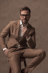 seated businessman holding one hand in pocket