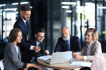Business team working on laptop to check the results of their work.