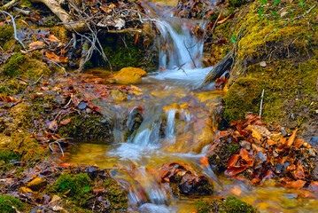 small waterfall on rushing mountain river, natural wild travel background