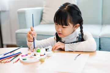Portrait of a girl sitting and painting at home