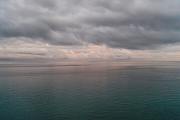 aerial foto of dramatic morning sky, glowing clouds over calm open water