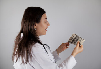Woman doctor  holding a dollar. Corruption or bribe concept.