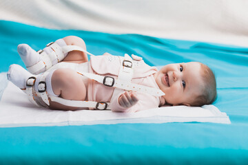 A baby wearing a harness that corrects hip dysplasia - obrazy, fototapety, plakaty