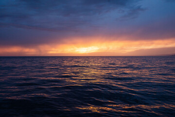 Calm golden sunset on open water while sailing the atlantic ocean