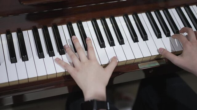 Close up of woman's hand playing on a piano