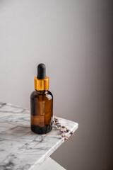 Glass brown bottle of serum with pipette for skin care, with sprigs of lavender. The concept of health and beauty. minimalism, copy space
