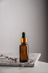 Glass brown bottle of serum with pipette for skin care, with sprigs of lavender. The concept of health and beauty. minimalism, copy space