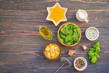 Prepared ingredients for cooking fritata or omelet on a dark wooden background. Spinach recipes.