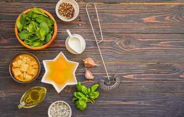 Prepared ingredients for cooking fritata or omelet on a dark wooden background. Spinach recipes.
