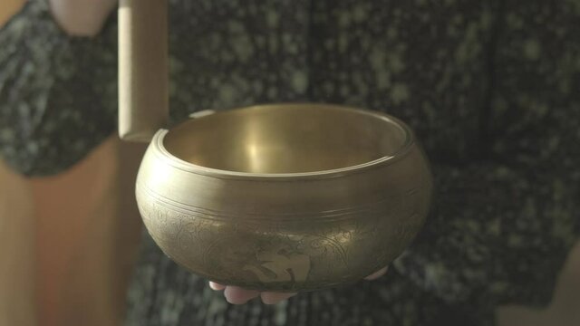 Female Hands Rotate a Millet Over a Tibetan Singing Bowl