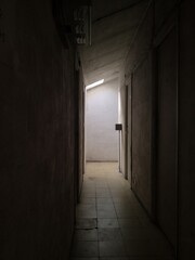 Old building with creepy corridor and a light at the enf
