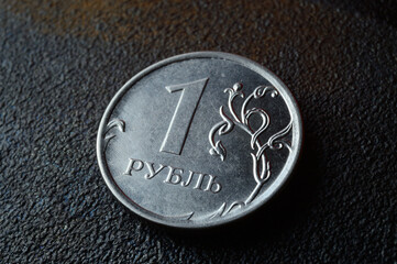 a Russian one ruble coin lies on a dark metal background. close-up
