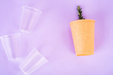 plastic drink cups and paper cup with green twig on very peri background, environmental pollution concept, no plastic