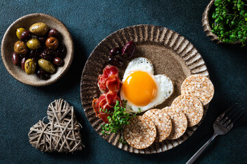 Breakfast on Women's Day - fried eggs in the shape of a heart and olives. Healthy breakfast. Rice cakes with eggs and hamon. Romantic breakfast. Top view.