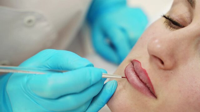 Permanent makeup. Beauty spa procedure. young woman. Face tattoo. Lip micropigmentation. Professional face microblading. Female cosmetology device. Copyspace. Mouth treatment. Dermatology video
