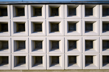 Wall with new empty cremation niches. Row with empty graves for cinerary urns. Cremation service, cemetery property. Columbarium area outside crematorium.