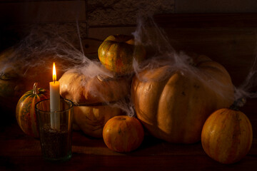 Pumpkins in the basement with cobwebs and a burning candle