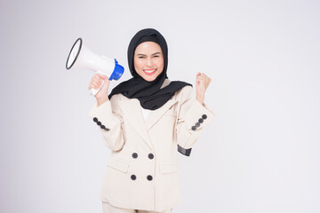 portrait of young beautiful muslim woman in suit using megaphone to announce over isolated white background studio..