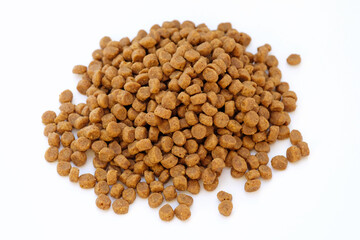 Dry food for cats, small granules on a white background. Animal food close-up top view. Granulated food for dogs and puppies.
