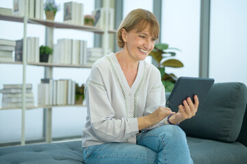 Happy Caucasian senior woman video call to family or friends, relax at home, smiling healthy senior retired grandparents, older grandparent technology concept