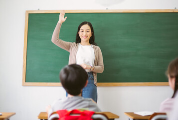 Portriat of Smiling female Asian teacher raising your hand and ask question to provide an example...