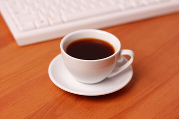 A cup of coffee and a computer keyboard.    