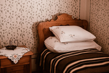 Bedroom with old bed in the countryside. Ethnic vintage retro floral warm bed comforter made of cotton bedding