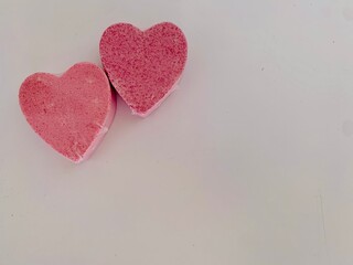 2 pink hearts on white background 
