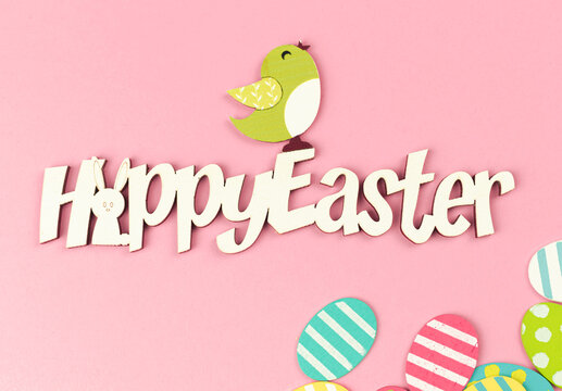 Happy easter spring holiday greeting card with colorful easter eggs on a bright pink background, top view photo, flat lay design