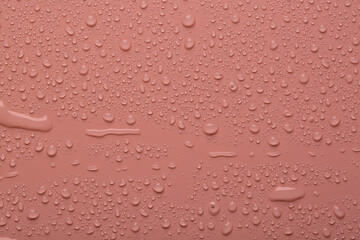 Water drops on coral  color  surface